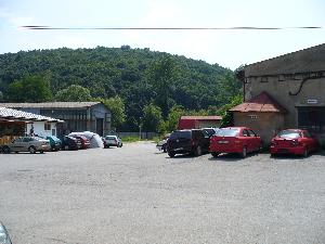 Obrázok - názov: Pohľad od S na J, na časť areálu bývalého v. d. SNAHA. V pozadí, za plotom, na úpätí zalesneného kopca tečie rieka Topľa.