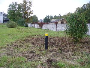 Obrázok - názov: Pohľad od JZ na SV, na vrt M-2 v ktorom bolo zistené znečistenie. Za plotom je železnica a za ňou rodinný dom.